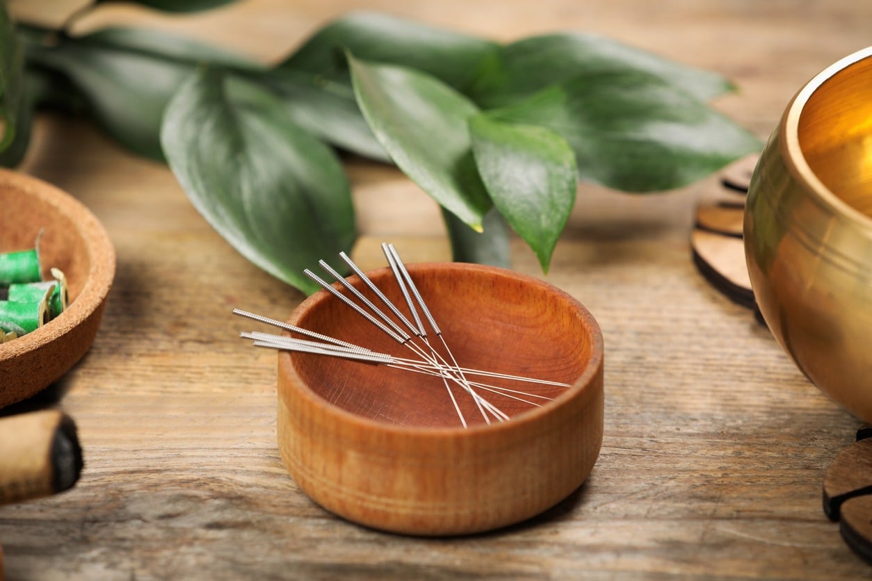 Needles over a wooden bowl for acupuncture in Calgary.